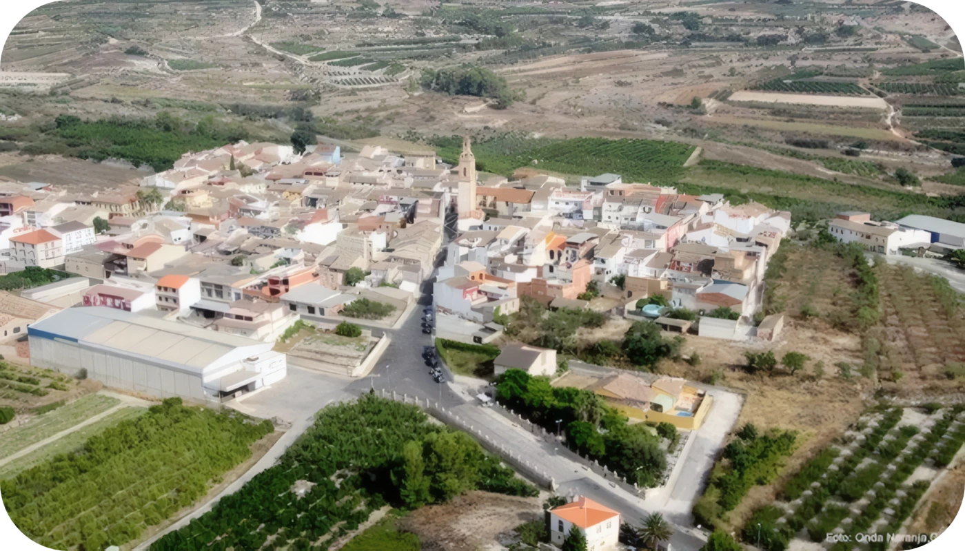 Vista aérea de pueblo con iglesia y campos de cultivo