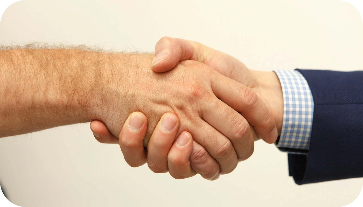 Apretón de manos entre dos personas en traje